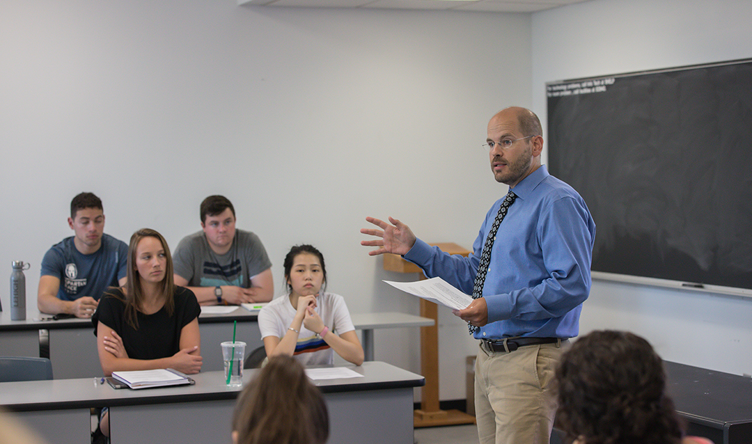 A professor lecturing to students in a classroom