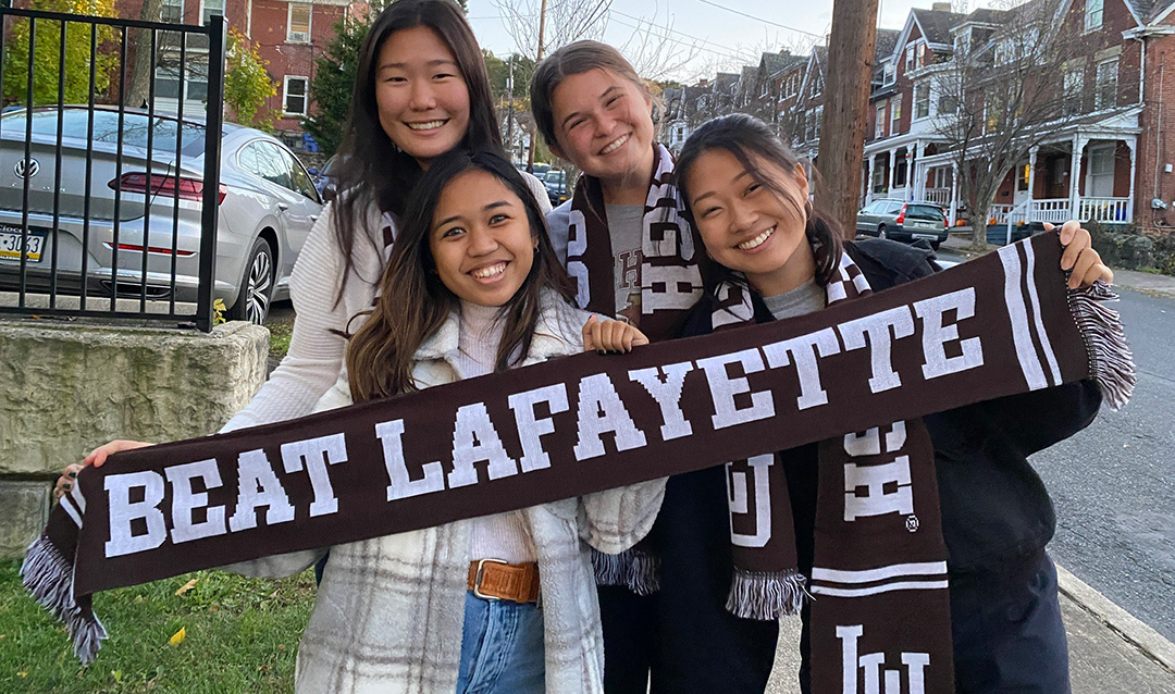 Four students holding Beat Lafayette scarf