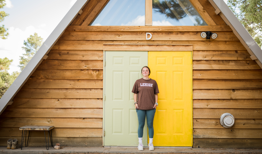 Emma Moriarty stands in front of a multi-colored door.