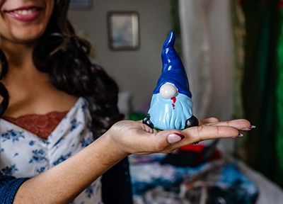 Woman holding pottery gnome in her hand